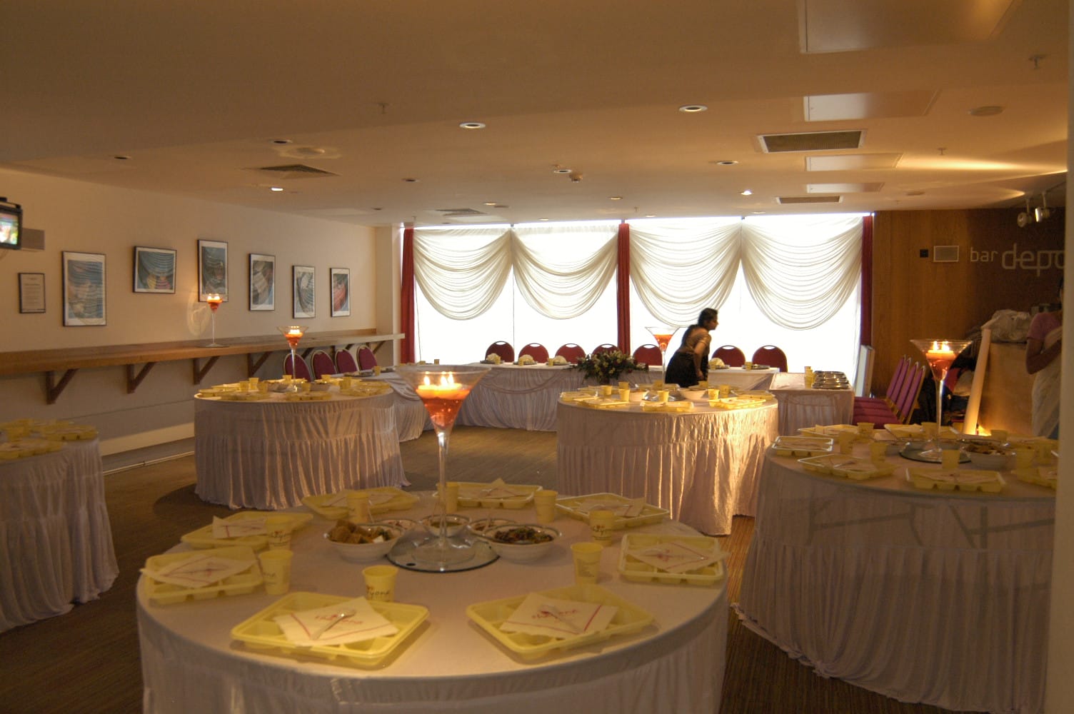 Bardepot's seating area with tables decorated with white table clothes and large candle display