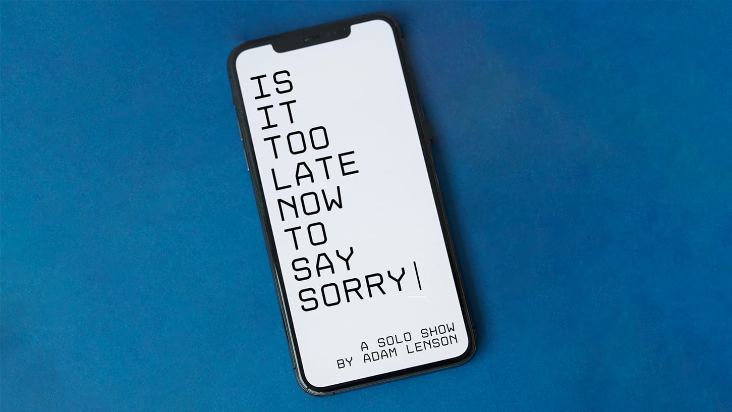 An iPhone on a blue background. The iPhone screen is white with black text reading 'Is It Too Late Now To Say Sorry'