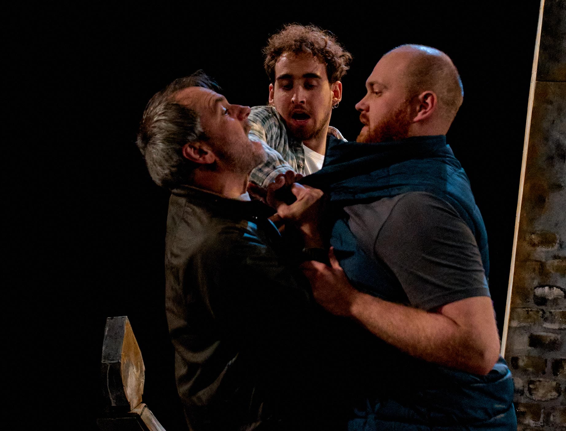 Performers on stage in The Freshwater Five - two men fight as a third tries to separate them.