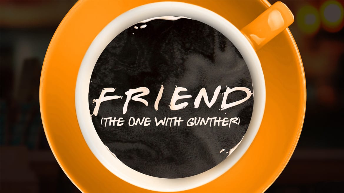 An orange coffee cup and saucer, filled with black coffee. Inside the cup, typography reads 'FRIEND (the one with Gunther)'