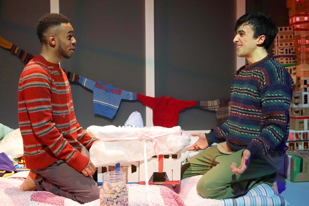The two male characters sitting in front of each other talking enthusiastically.