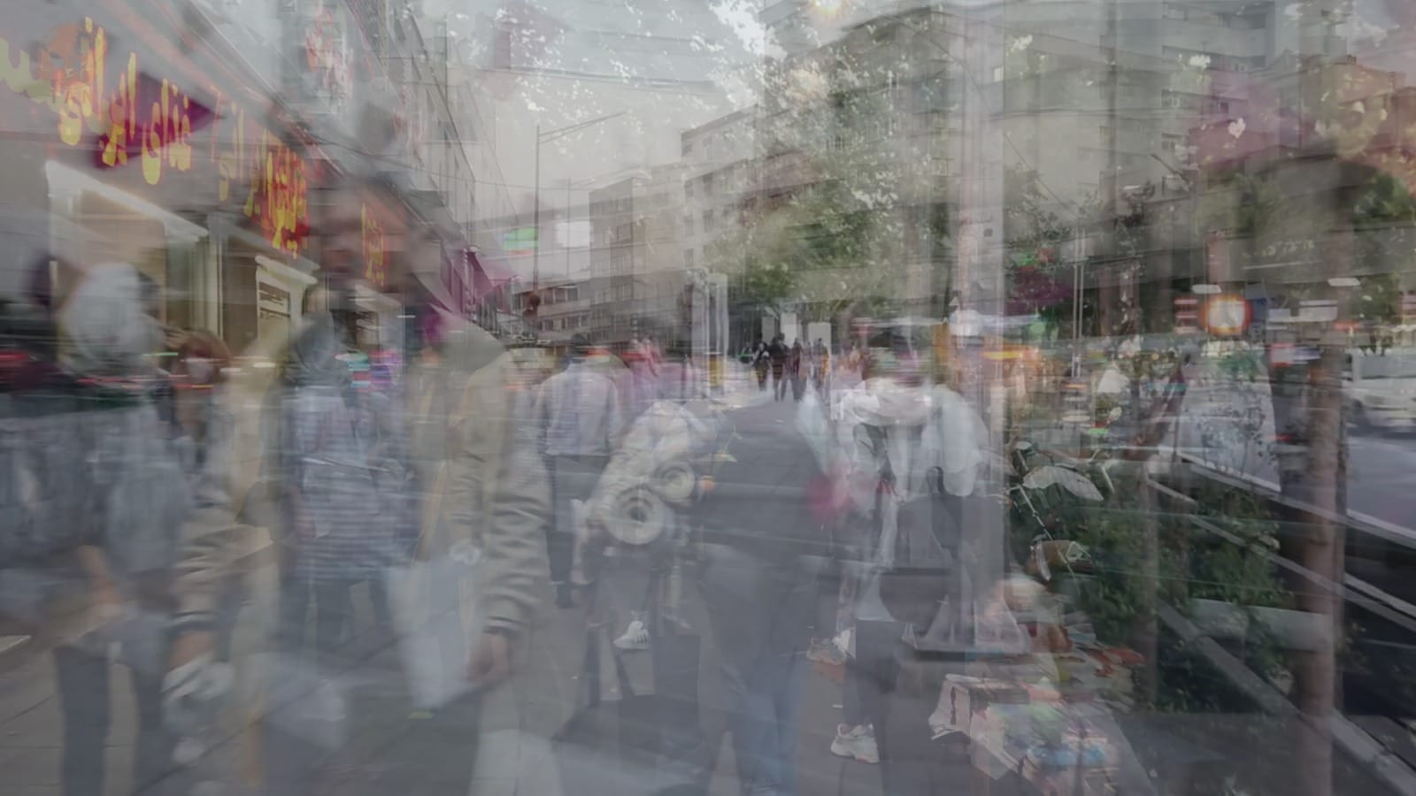 A busy, double-exposed photograph of a bustling city. People walk in different directions, overlayed with motion shots of traffic, shops and blocks of flats.