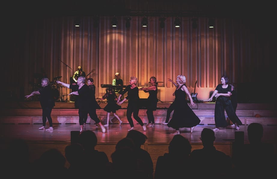 A group of women of all ages performing on stage.