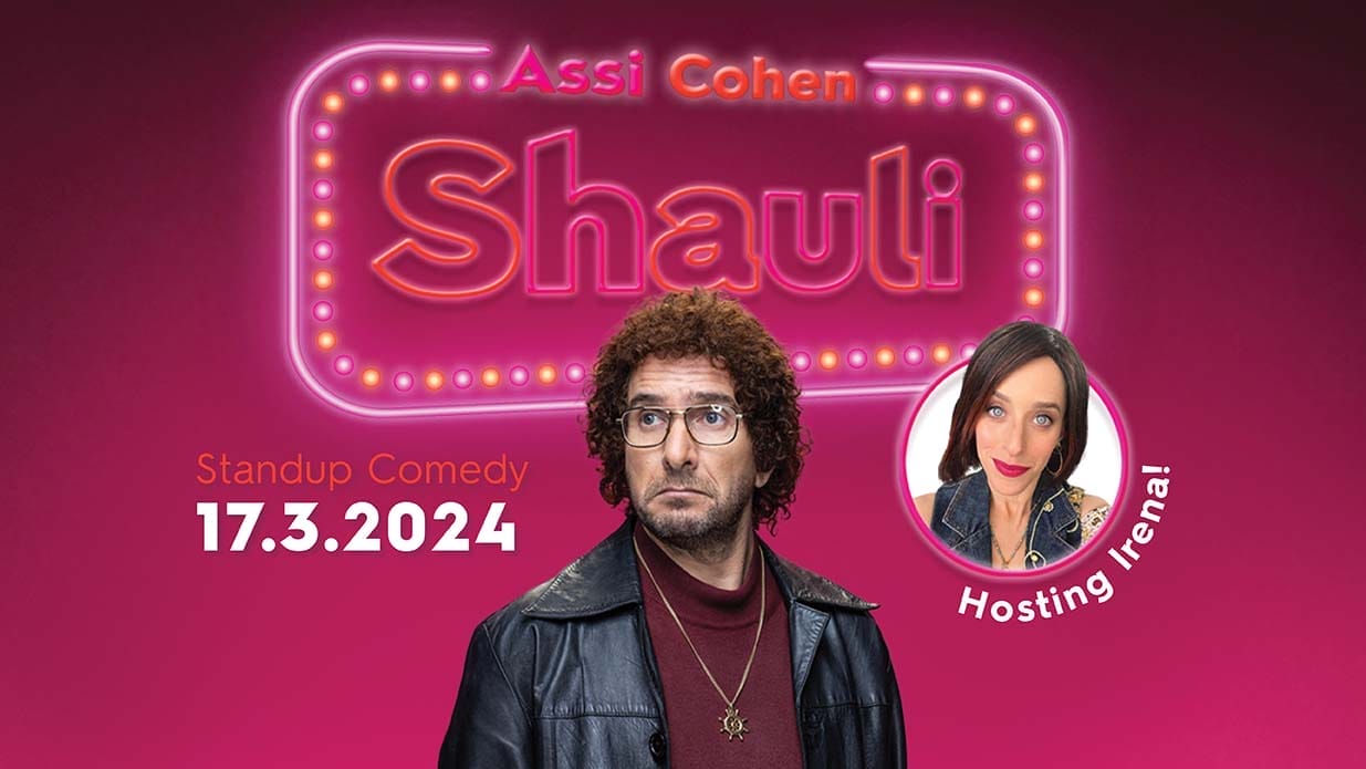 Comedian Assi Cohen dressed as the character Shauli, wearing metal rimmed glasses and a leather jacket. Behind him, neon text on a pink background reads Assi Cohen Shauli.