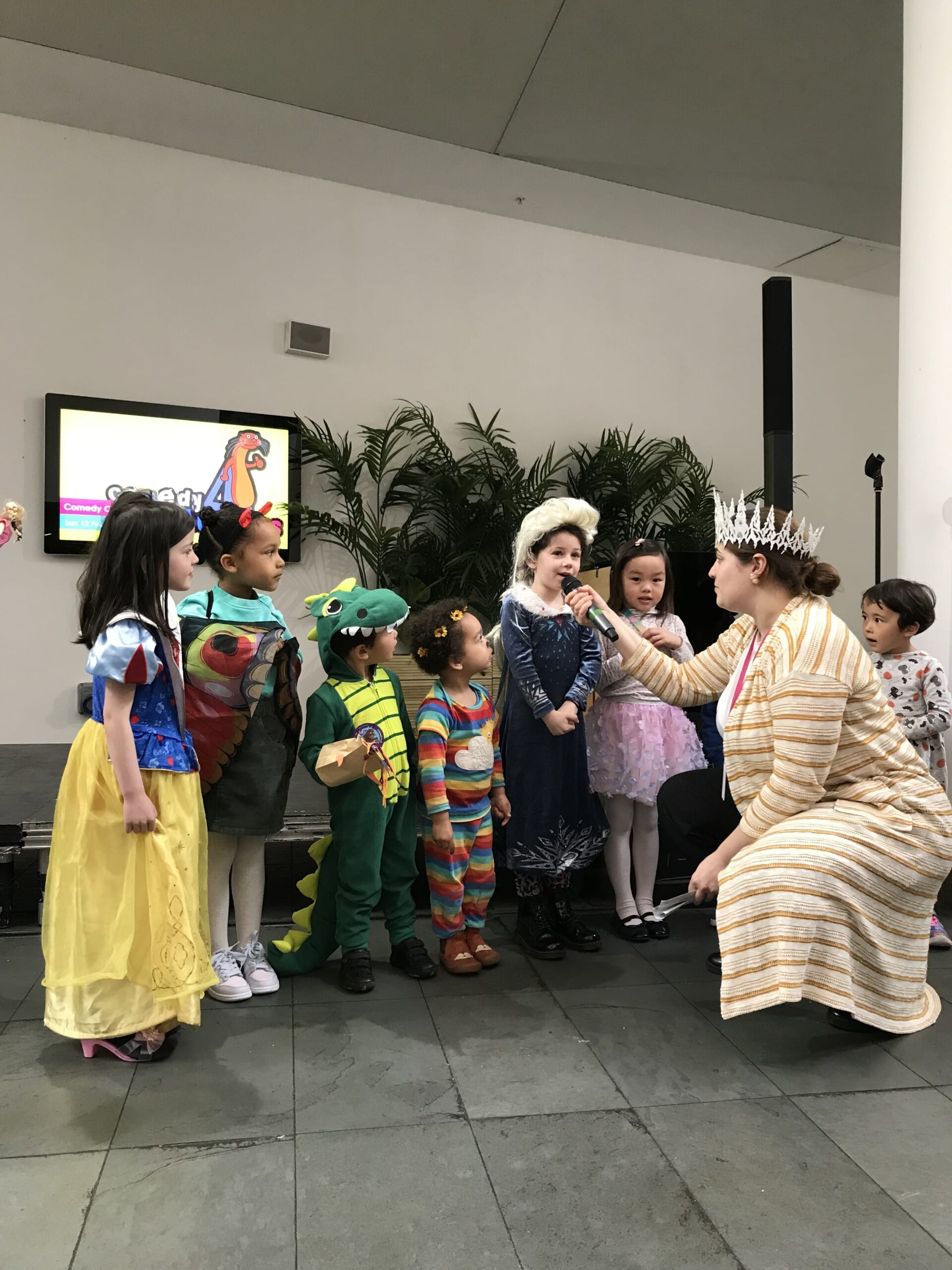 A group of children in colourful costumes in artsdepot's costume parade! Costumes include Snow White, the very hungry caterpillar, Queen Elsa, a crocodile, and more!