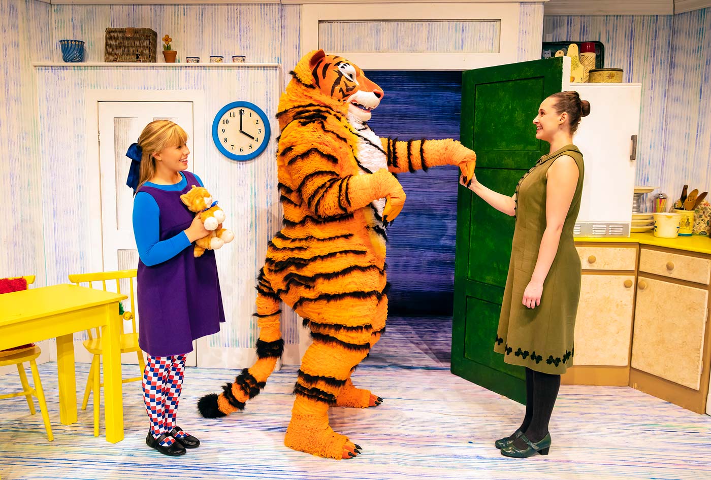 The character of Tiger in The Tiger Who Came to Tea shakes the character Mummy's hand.