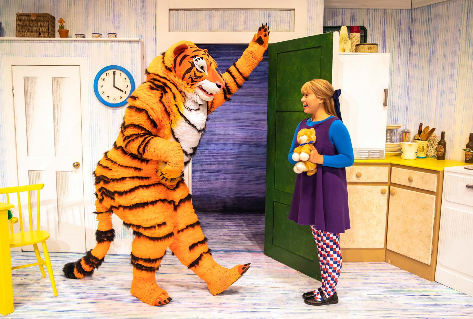 The character of Tiger in The Tiger Who Came to Tea bows in greeting to the character Sophie who is holding a cuddly toy tiger.