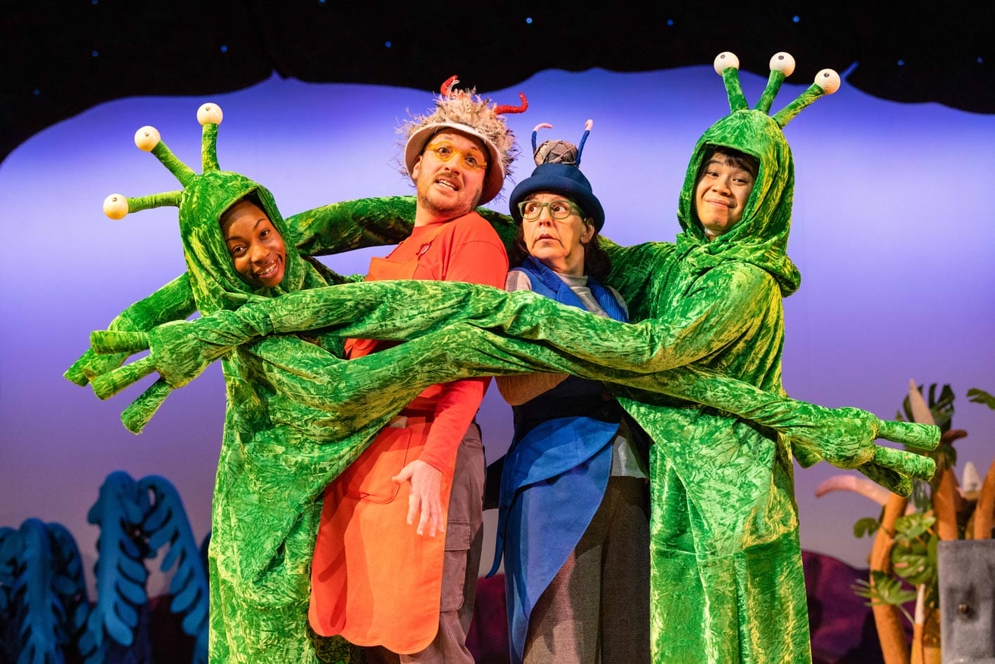 The Smed and the Smoos are dressed in alien green costume, trapping their parents in a group hug.