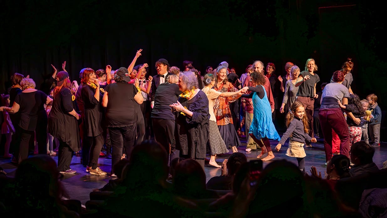 A stage full of people of all ages dancing together.