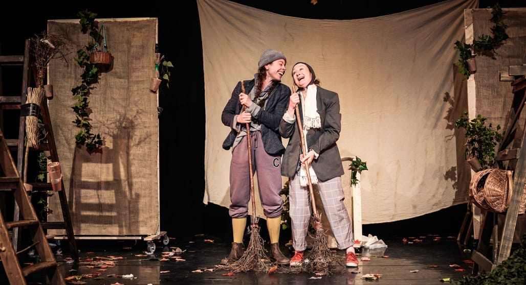 Two performers accompanied by a tree in the backdrop, creating a natural setting, joyfully interacting with eachother.