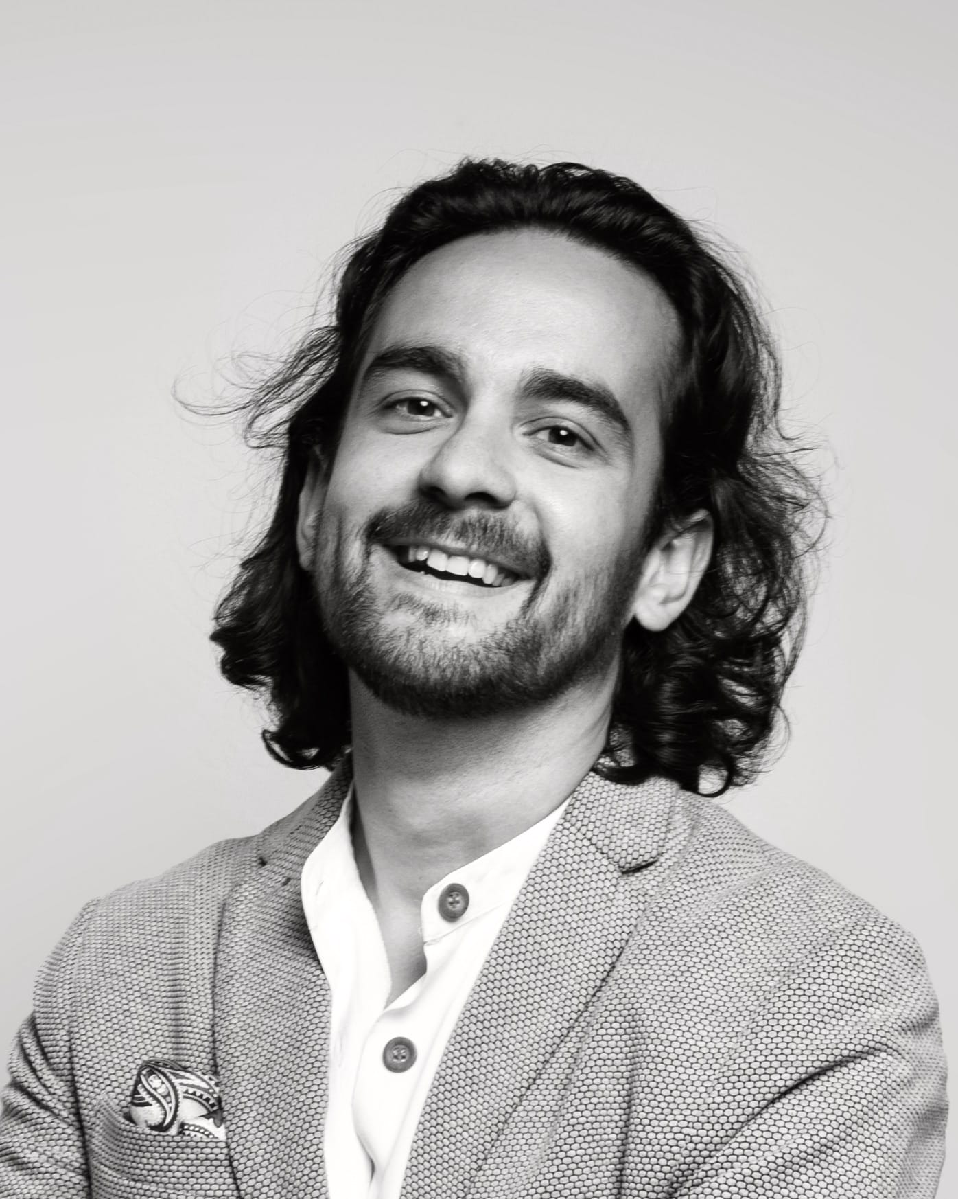 mixed race Scottish and Indian 30year old man with dark hair smiling at camera in black in white