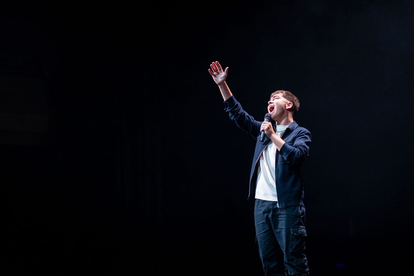 A young performer singing on stage