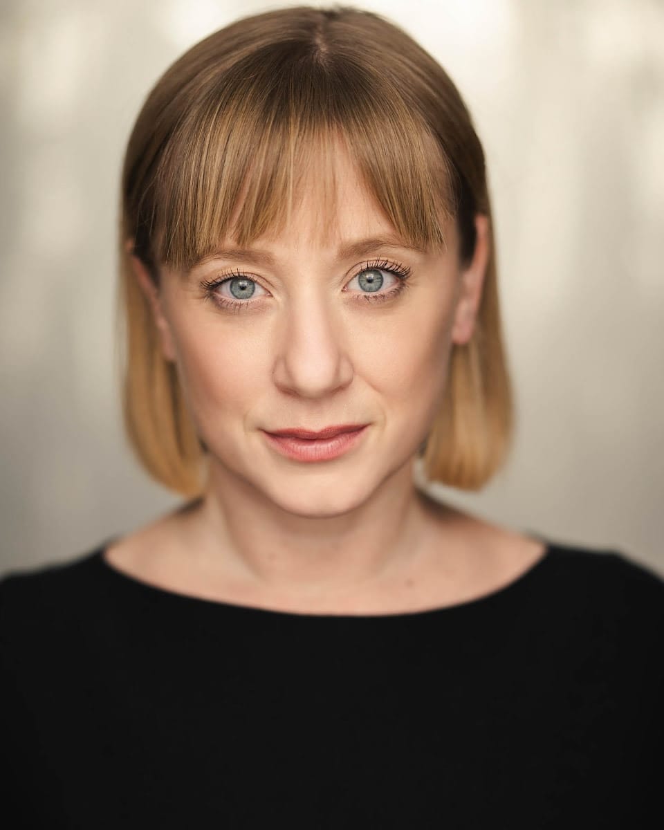 Head shot of Helen Phillips. A white woman with a short blond hair in a black top.