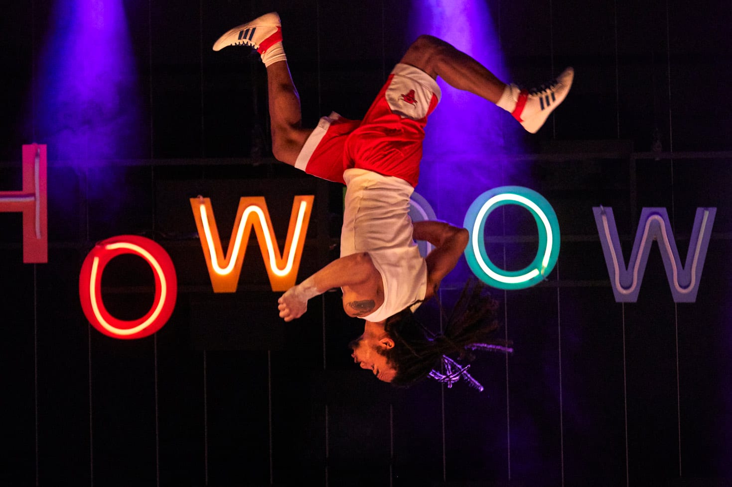 An acrobat on stage in Showdown is pictured mid tumble, he is upside down.