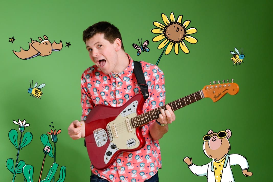 David Gibb plays guitar against a green background with cartoon nature drawings.