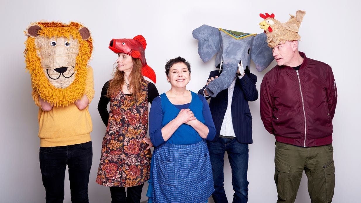 A woman stands next to four people wearing animal face masks.