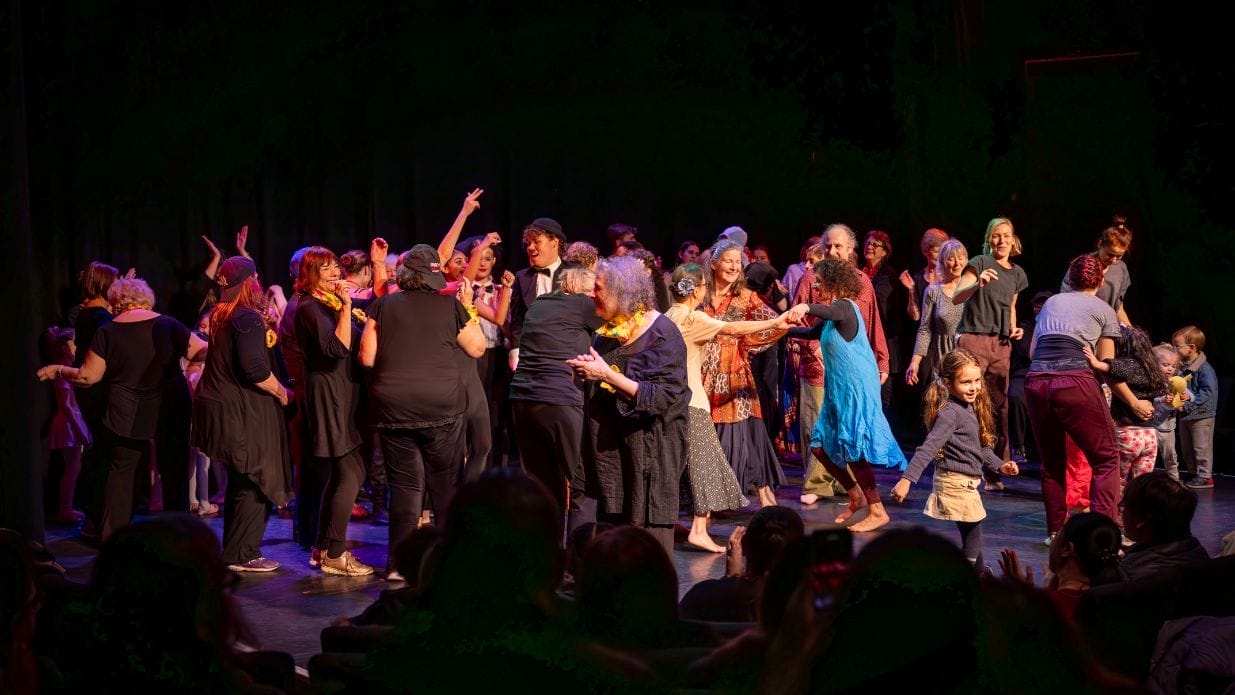 A group of people gathered on stage dancing.